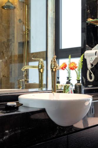 a white sink with a gold faucet on a counter at Ravatel Style Hotel Bac Giang in Bắc Giang