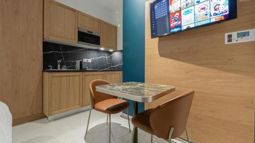 een kleine keuken met een tafel en 2 stoelen bij Corner-Set Cholet Centre in Cholet