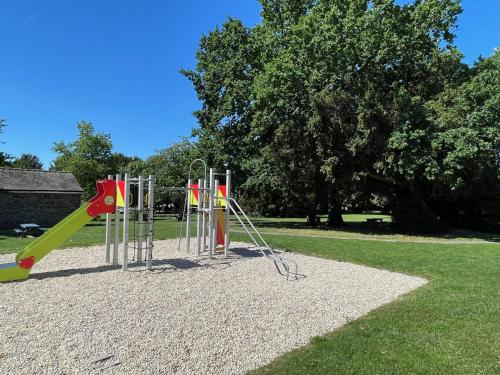 a playground with a slide in a park at L'orée du parc in Retiers