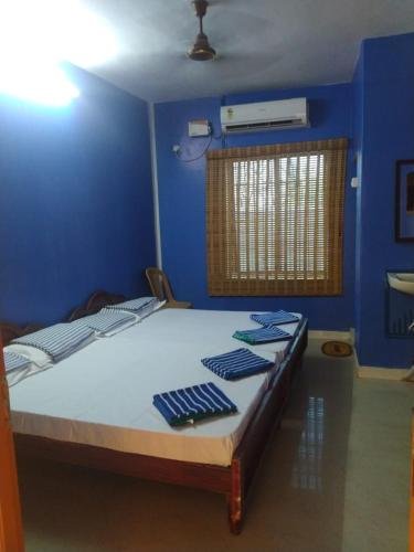 1 dormitorio con 1 cama en una habitación azul en New City Tower Residency, en Tiruchchendūr