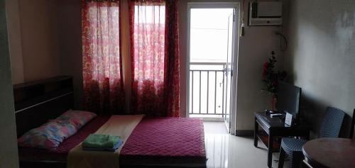 a small bedroom with a bed and a window with at Kdorzmoonwalk Kassel Residences Paranaque in Manila