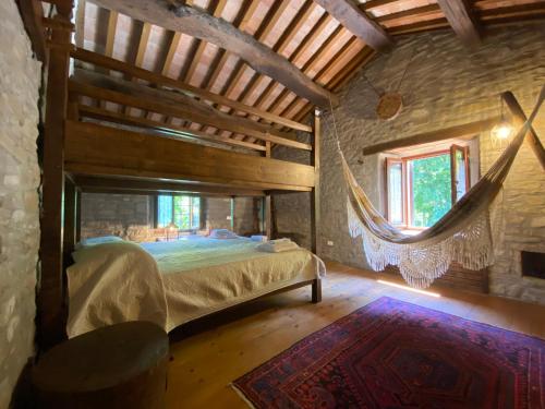 sypialnia z łóżkiem i hamakiem w pokoju w obiekcie Borgo Corniola B&B Naturista w mieście Marradi
