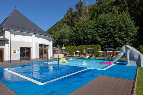 een zwembad met een glijbaan en een speeltuin bij Hotel Verde Montana Wellness & Spa in Kudowa-Zdrój