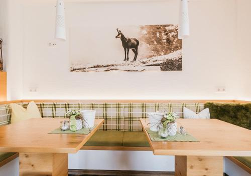 a dining room with two tables and a dog on the wall at HOFERHOF Schladming -Dachstein in Schladming