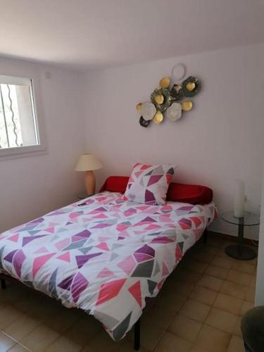 une chambre avec un lit avec une couette colorée dans l'établissement Le Mas Blanc, à Aumelas