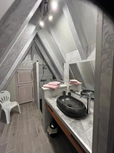 - une salle de bains mansardée pourvue d'un lavabo en pierre dans l'établissement roquebrune, à Saint-Alvère