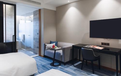a hotel room with a bed and a television at Just Palace Hotel in Taipei