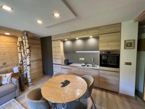 une salle à manger avec une table et une cuisine dans l'établissement Le Sapin B19 Megeve - Demi Quartier, à Megève