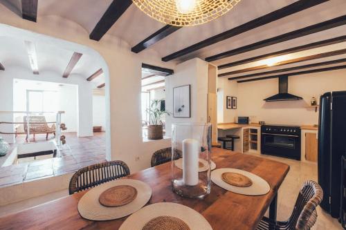 a kitchen and dining room with a wooden table and chairs at Casa Ilusión Altea in Altea