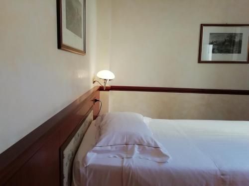 a bedroom with a bed and a lamp on the wall at Phi Hotel Dei Medaglioni in Correggio
