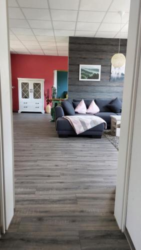a living room with a couch and red walls at Ferienwohnung alte Stepperei in Schwarzenberg
