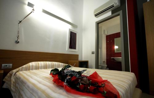 a bedroom with a bed with red flowers on it at San Rocco Hotel in Scanzorosciate