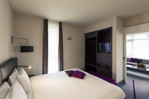a hotel room with a bed and a television at Mercure Hotel Groningen Martiniplaza in Groningen