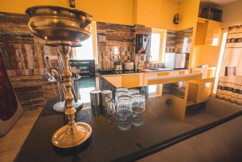 a counter with wine glasses on it in a kitchen at mezzanine villa W/T Hot Tub Jacuzzi in Kālapettai