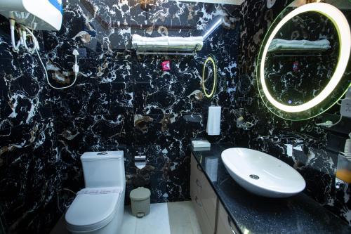 ein Badezimmer mit Waschbecken, Toilette und Spiegel in der Unterkunft Kavassu Heritage Haveli in Jhunjhunūn