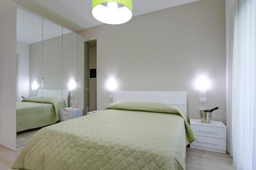 a bedroom with two beds and a large mirror at Residence Armony in Misano Adriatico