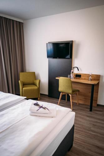 a hotel room with a bed and a desk and chairs at Landgasthof-Wemmer in Großrückerswalde