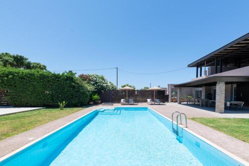 a swimming pool in the backyard of a house at Marane Deluxe House in Ialyssos