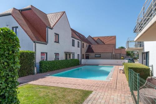 a swimming pool in the backyard of a house at Sans Souci - residentie Neoportus in Nieuwpoort