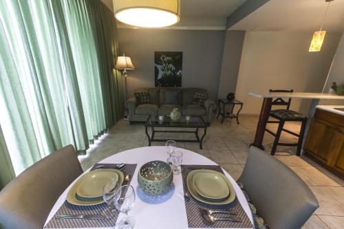 a dining room with a table and a living room at Altos de Fontana by Macondo Collection in Managua