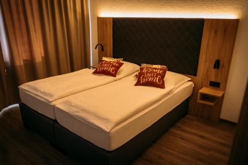 a bedroom with a bed with two pillows on it at Landgasthof-Wemmer in Großrückerswalde