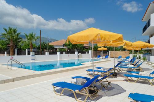 a pool with blue chairs and yellow umbrellas at Lecini Studios in Laganas