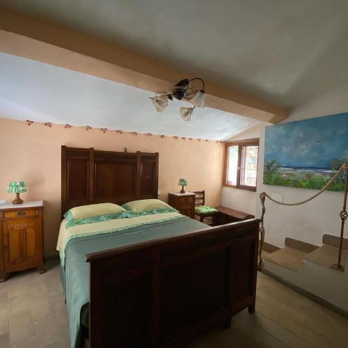 a bedroom with a bed with a wooden headboard at La Nicchia di Franco in Montignoso