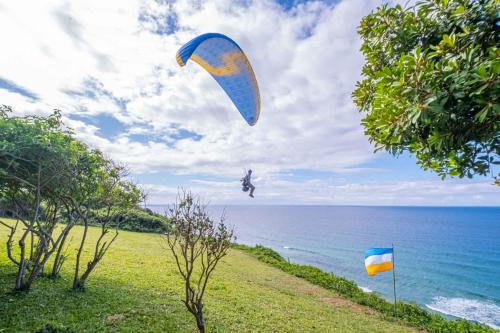 a person is flying a kite over the ocean at Sky Island Resort in Ponta Malongane
