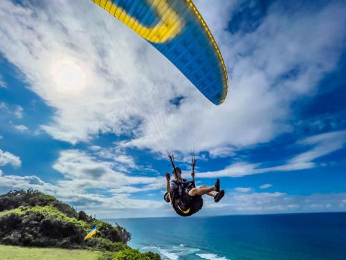 una persona está volando en el aire con un paracaídas en Sky Island Resort en Ponta Malangane