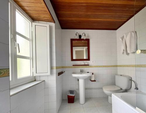 a white bathroom with a sink and a toilet at Grupo Las Catedrales - Casa Amadora in Barreiros
