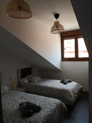 a bedroom with two beds and two windows at Aldea Bricia 20 BC in Posada de Llanes