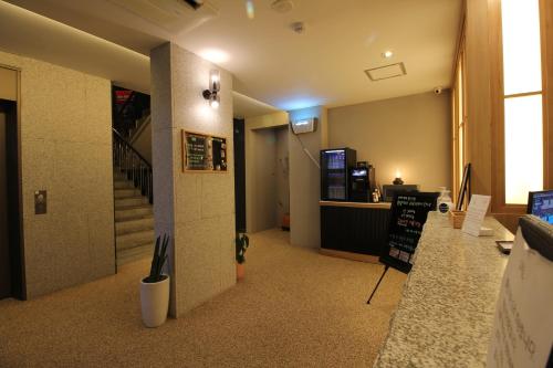 a lobby with a counter and stairs in a building at HOTEL701 Masan in Changwon