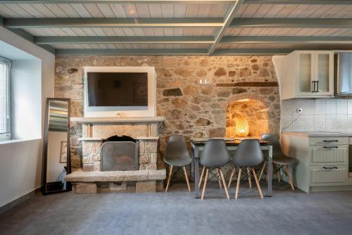 a kitchen with a table and a stone fireplace at Traditional Stone House in Thános