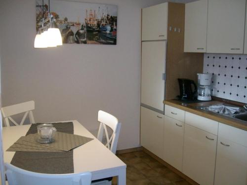 cocina con mesa y encimera en Strandwohnung Deichblume, en Neuharlingersiel