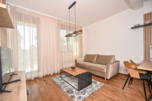 a living room with a couch and a table at All Seasons Residence in Zlatibor