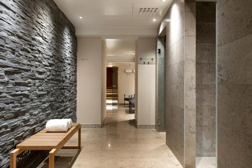 um corredor com uma parede de pedra e um banco em Elite Hotel Mimer em Umeå