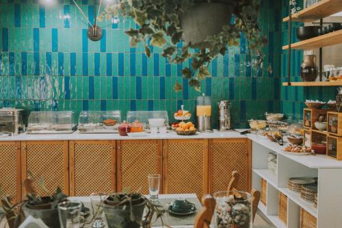 a kitchen with blue tiled walls and a table with food at Creta Vitalis in Kalathas