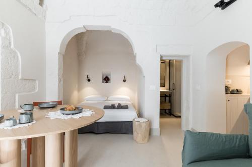 a hotel room with a bed and a table at Petragrigia Vacation Suite in Ostuni