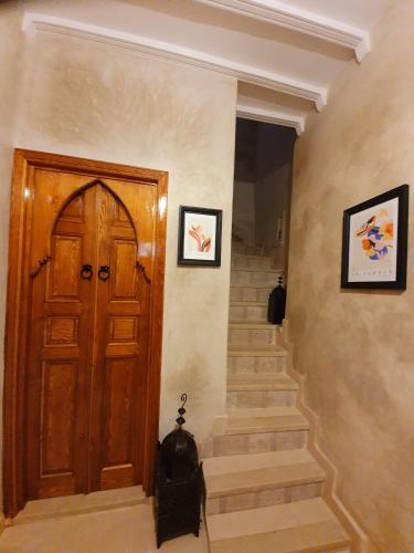 a hallway with a wooden door and stairs at Dar Malika in El Jadida