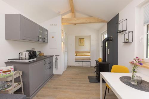 a kitchen with a counter and a table in a room at Tinyhouse am km8komma2 in Bad Berleburg