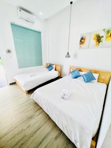 a bedroom with two beds and a large window at D'Villa Hotel - Homestay in Kon Tum
