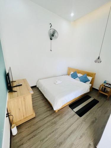 a bedroom with a bed and a desk with a lamp at D'Villa Hotel - Homestay in Kon Tum