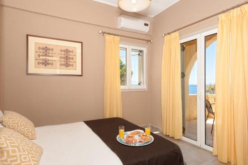 a bedroom with a bed with a tray of food on it at Creta Vitalis in Kalathas