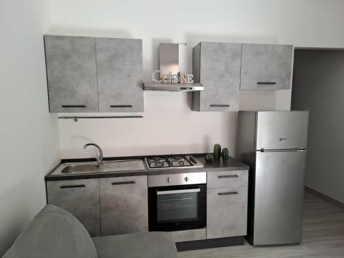 a kitchen with a stove and a refrigerator at InCanti Salentini Apartments in Surbo