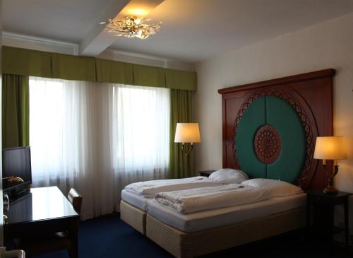 a bedroom with a large bed with a green headboard at Hotel-Restaurant Heute in Frechen