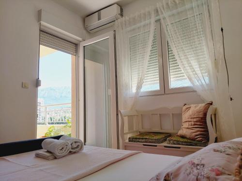 a bedroom with a window and a bed with towels at Aska Apartment in Bar
