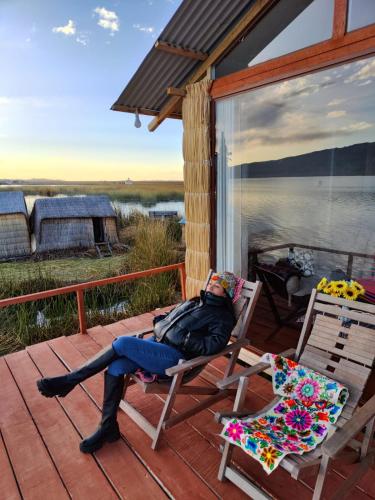 a woman sitting on a chair on a porch at TITICACA JALTAWI LODGE in Puno