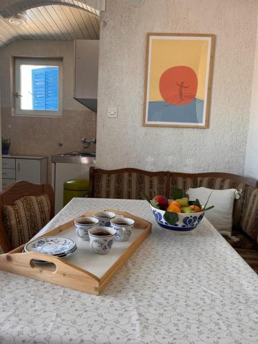 a table with a tray with bowls of fruit on it at Sunny view Apartman in Barbat na Rabu