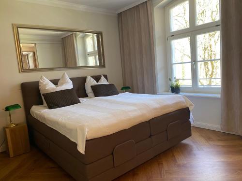 a bedroom with a large bed with a large mirror at Jagdschloss Suite - premium castle hideway in Hohen Niendorf