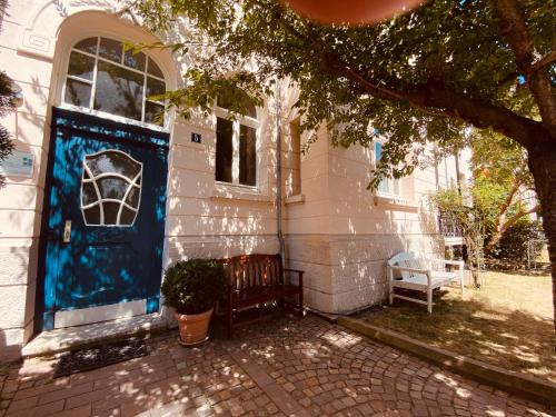 una casa con una porta blu sul lato di Jugendstil-Altbauwohnung mit Dachterrasse direkt an der Karlsaue a Kassel